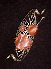 Sterling silver spirals and fire-coloured copper leaves. First piece of fretwork produced for a college project.